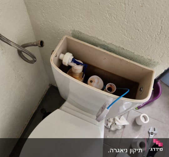 מיכל שירותים פתוח עם כלים לתיקון צנרת